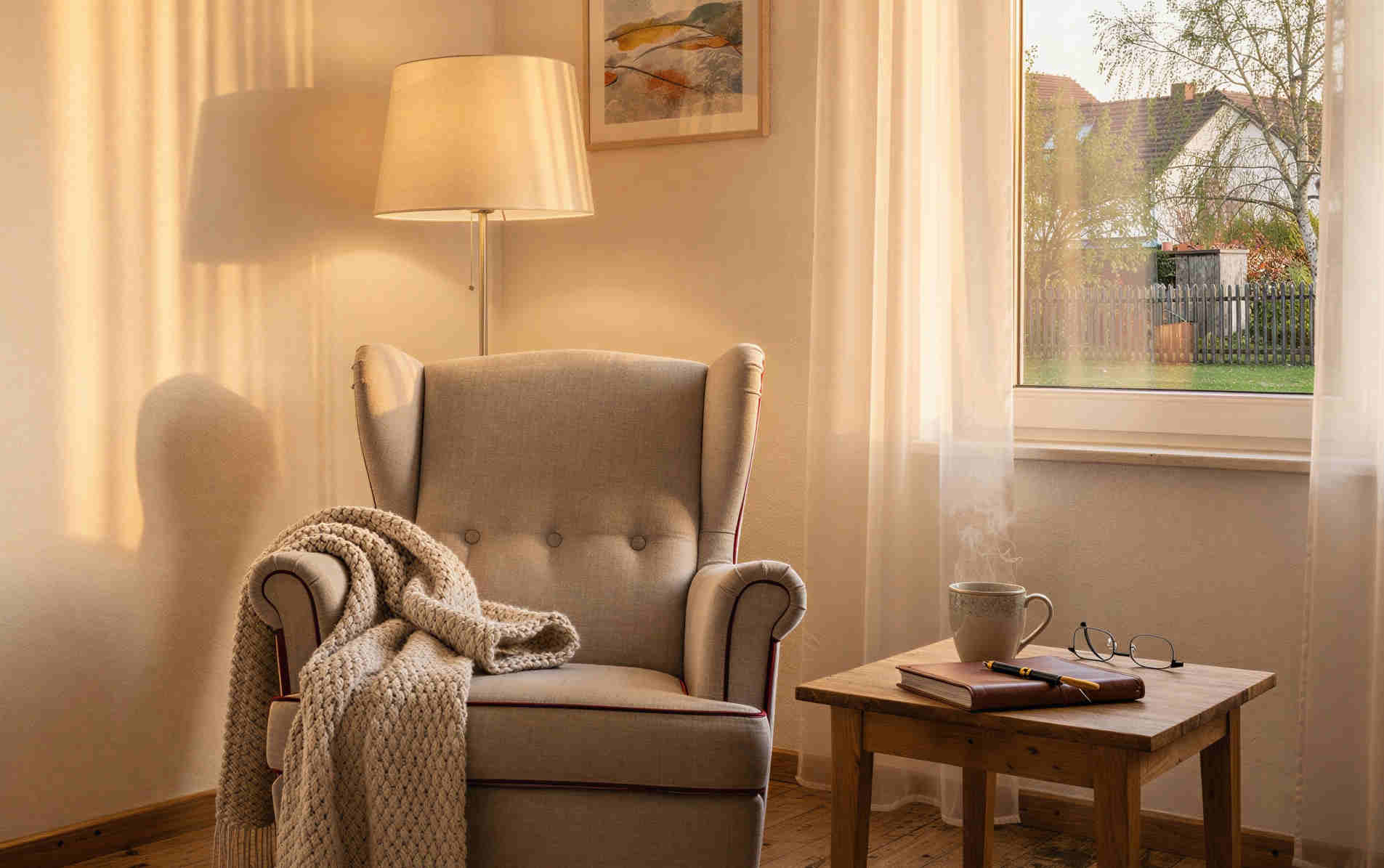 Ruhiger Lesesessel mit Decke am Fenster